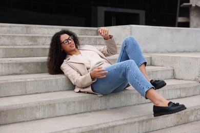 Photo of Injured woman on stairs outdoors after fall. Dangerous accident