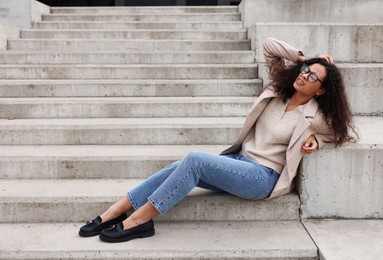 Photo of Woman with injured head on stairs outdoors after fall. Dangerous accident