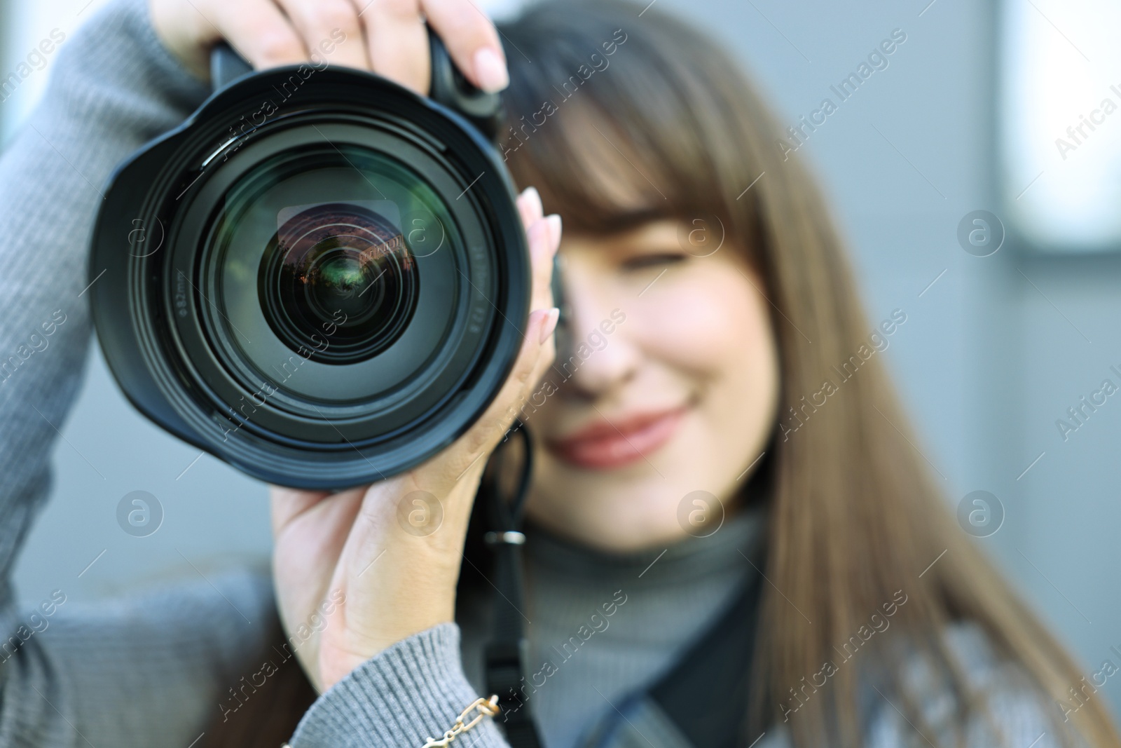 Photo of Professional photographer taking picture with camera outdoors, selective focus