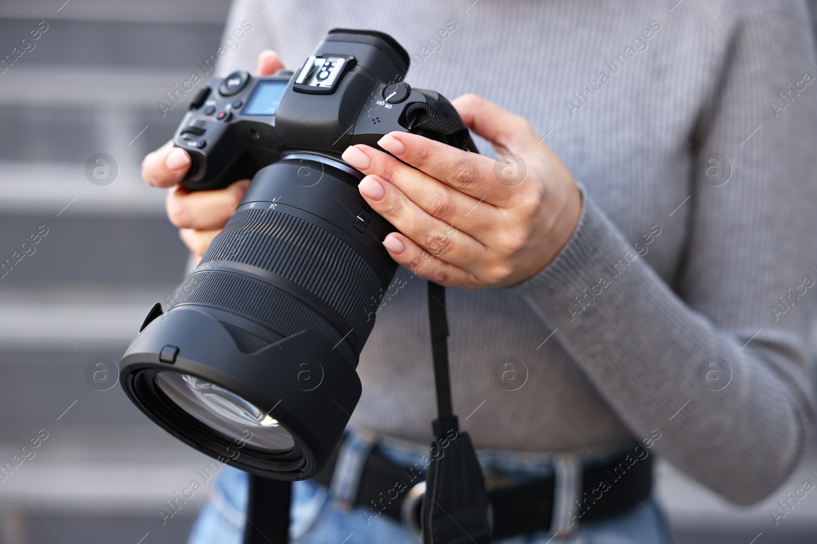 Photo of Professional photographer with digital camera outdoors, closeup