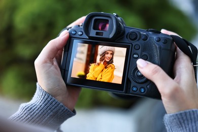 Photo of Professional photographer with digital camera outdoors, closeup