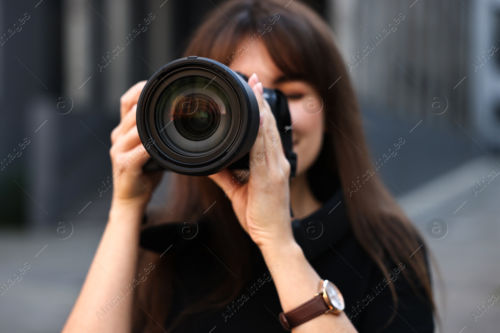 Photo of Professional photographer taking picture with camera outdoors, selective focus