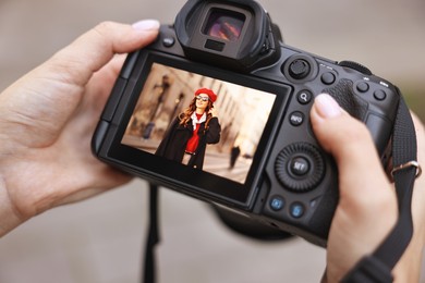 Photo of Professional photographer with digital camera outdoors, closeup