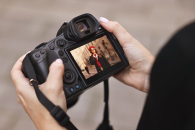 Photo of Professional photographer with digital camera outdoors, closeup