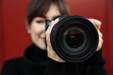 Photo of Professional photographer taking picture with camera outdoors, selective focus