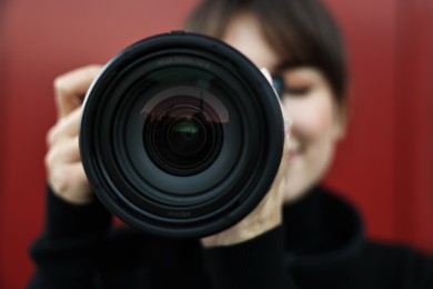 Photo of Professional photographer taking picture with camera outdoors, selective focus