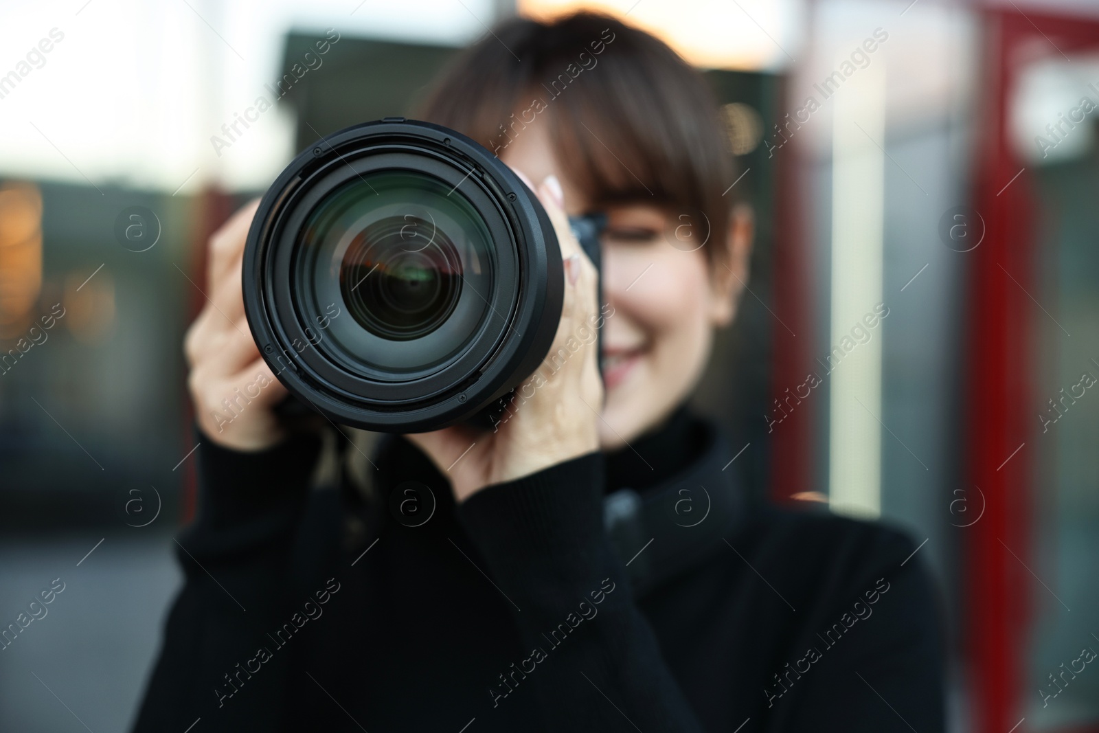 Photo of Professional photographer taking picture with camera outdoors, selective focus