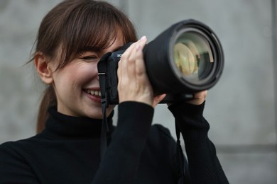 Photo of Professional photographer taking picture with camera outdoors, selective focus