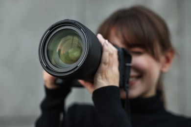 Photo of Professional photographer taking picture with camera outdoors, selective focus