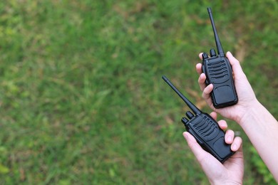 Photo of Woman with walkie talkies outdoors, closeup. Space for text