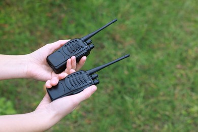 Photo of Woman with walkie talkies outdoors, closeup. Space for text