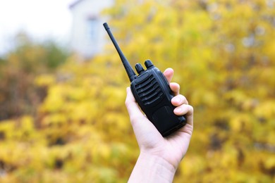 Photo of Woman with walkie talkie in park, closeup