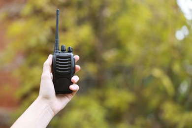 Photo of Woman with walkie talkie outdoors, closeup. Space for text