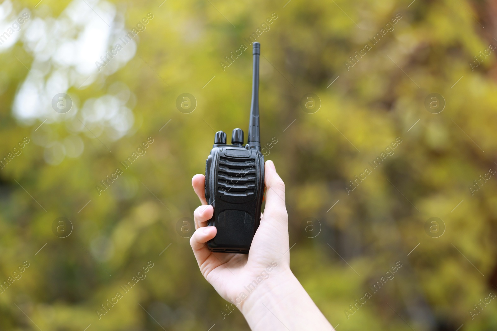 Photo of Woman with walkie talkie in park, closeup