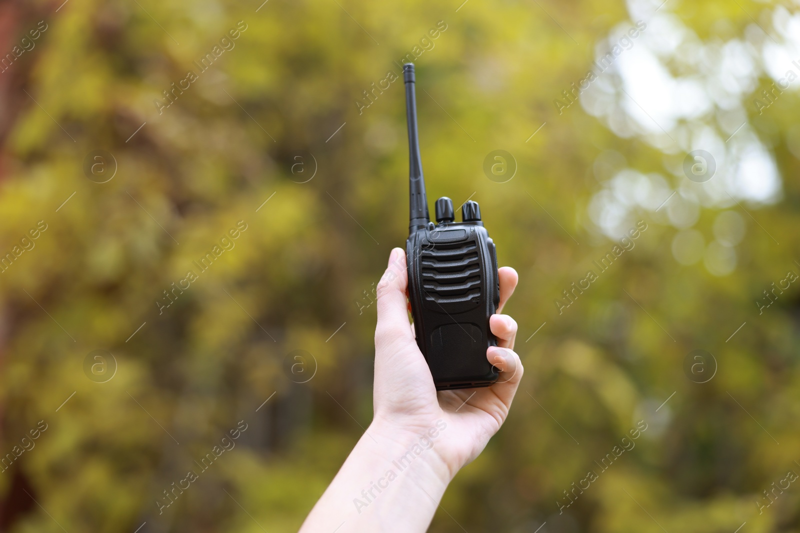 Photo of Woman with walkie talkie in park, closeup