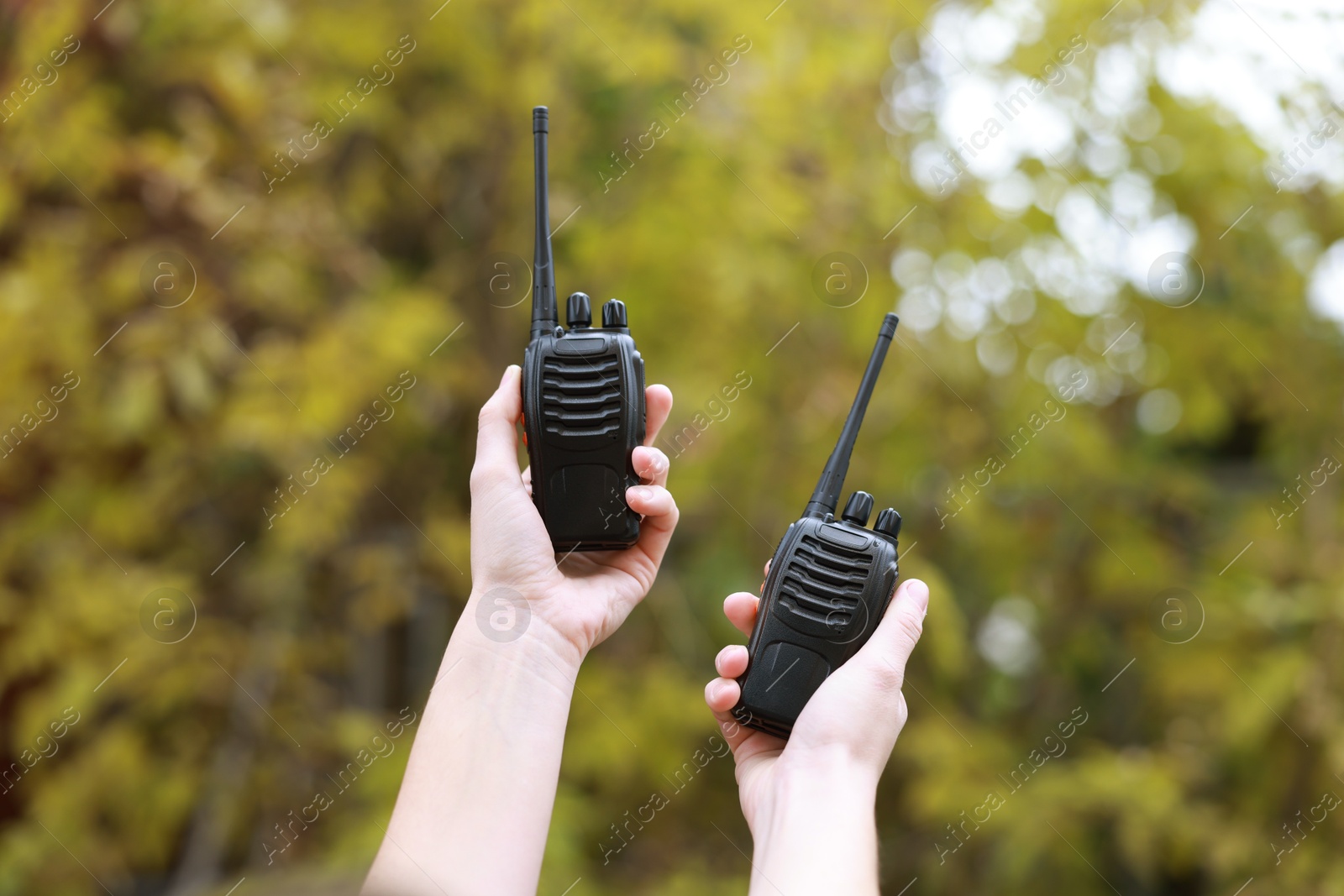 Photo of Woman with walkie talkies in park, closeup