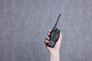 Photo of Woman with walkie talkie against grey background, closeup. Space for text