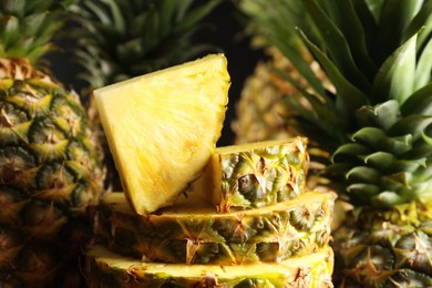 Slices of ripe pineapples on blurred background, closeup