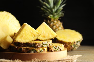 Photo of Slices of ripe pineapple on wooden table, closeup