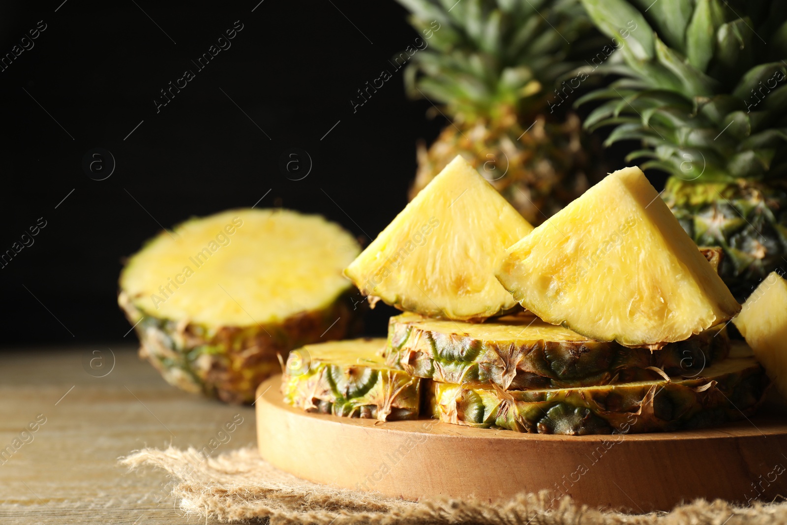 Photo of Slices of ripe pineapple on wooden table, closeup