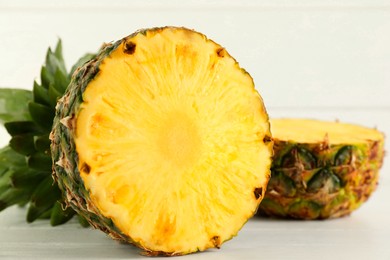 Photo of Cut fresh ripe pineapple on white wooden table, closeup