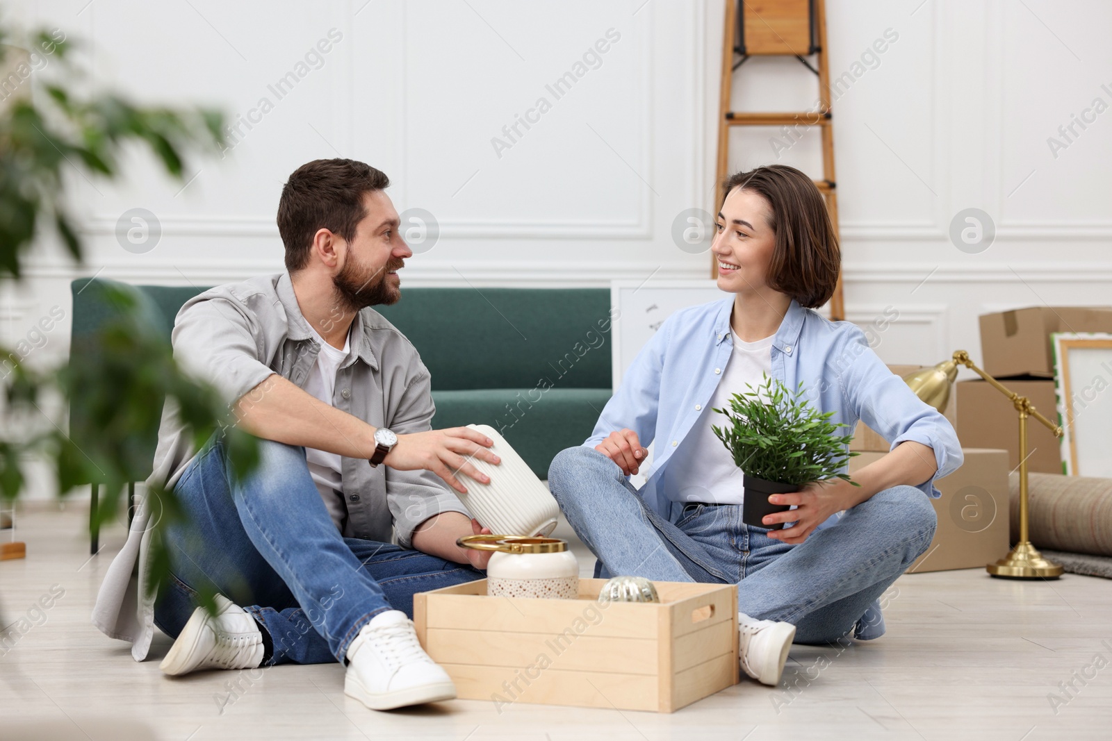 Photo of Moving day. Happy couple unpacking their belongings in new home