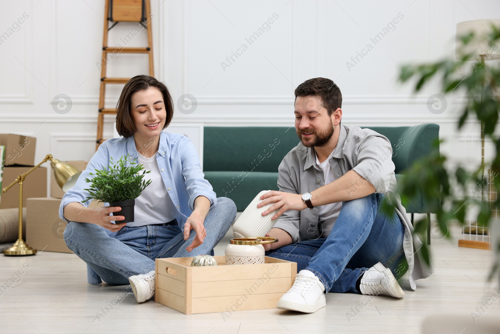 Photo of Moving day. Happy couple unpacking their belongings in new home