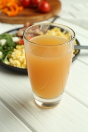 Photo of Tasty brunch. Glass of apple juice and scrambled eggs with bacon served on white wooden table, closeup