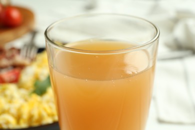 Photo of Glass of fresh apple juice and tasty brunch served on table, closeup