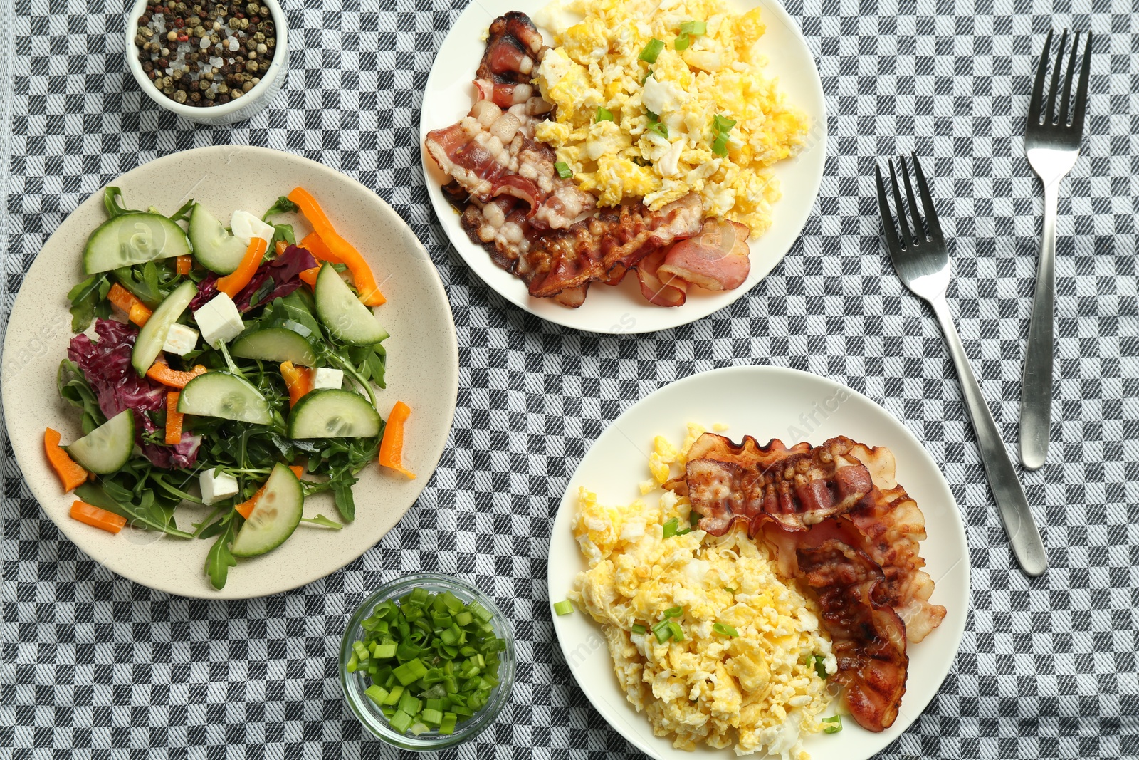 Photo of Tasty brunch. Delicious scrambled eggs, bacon and salad served on table, flat lay