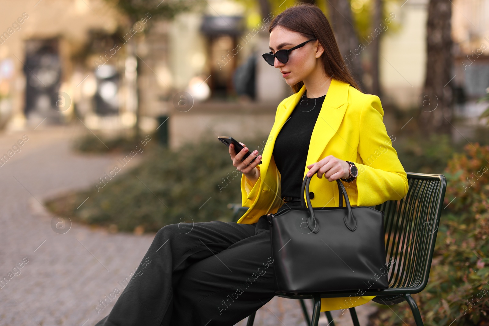 Photo of Businesswoman in stylish suit with smartphone outdoors. Space for text