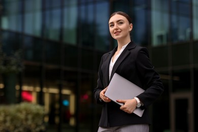 Photo of Woman in stylish formal suit with laptop outdoors. Space for text