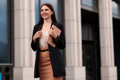 Photo of Woman in stylish formal suit with tablet outdoors. Space for text