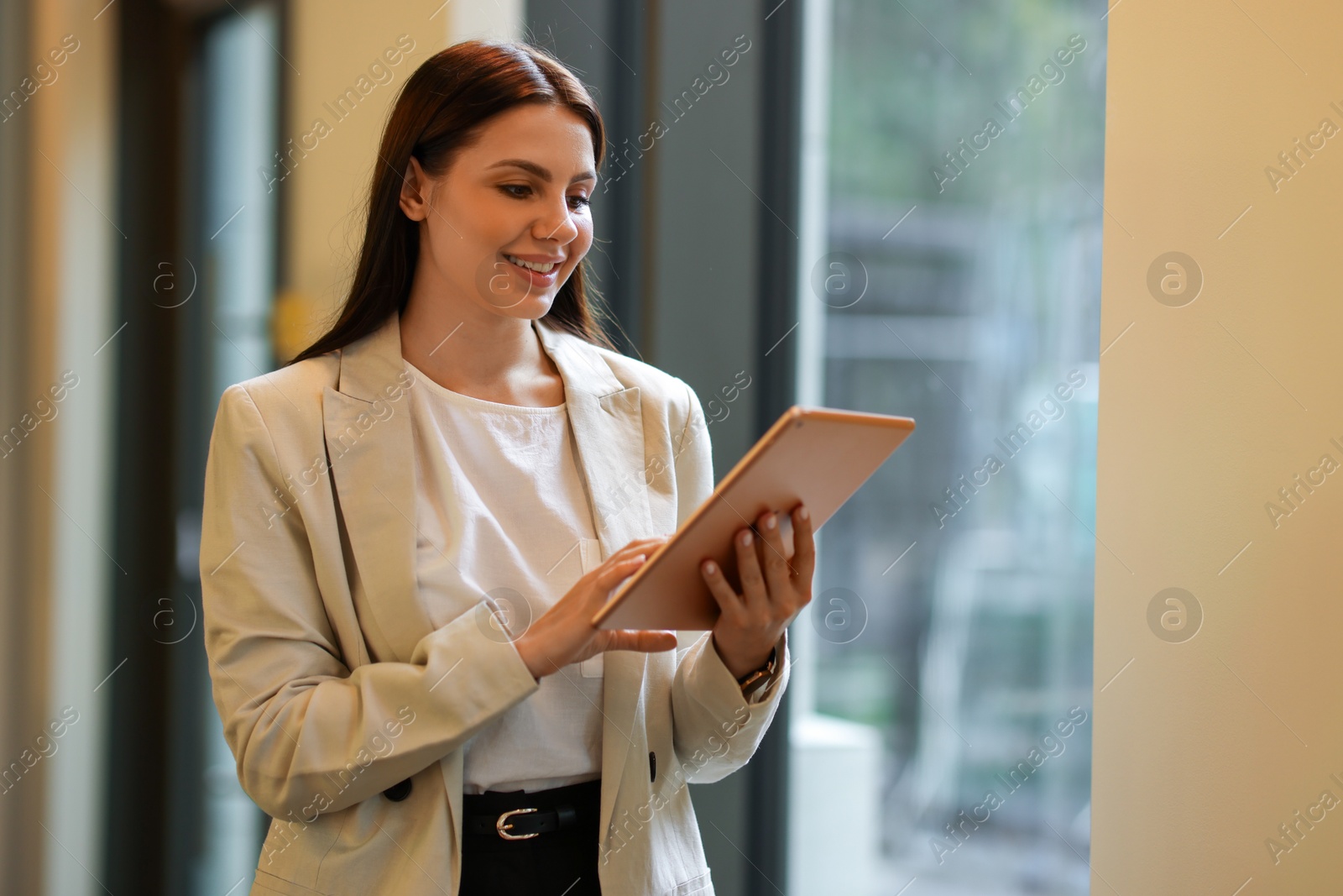 Photo of Woman in stylish formal suit with tablet indoors