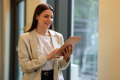 Photo of Woman in stylish formal suit with tablet indoors