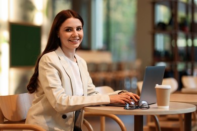 Photo of Woman in stylish formal suit working at table indoors