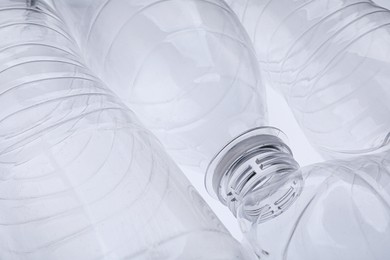 Photo of Empty plastic bottles on white background, closeup