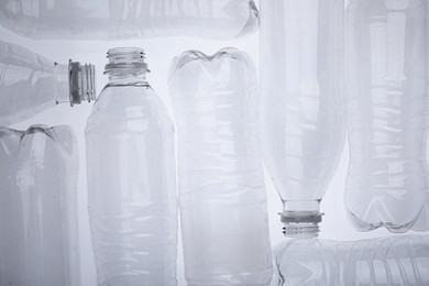 Photo of Empty plastic bottles on white background, top view