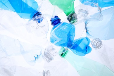 Photo of Crumpled plastic bottles on white background, closeup