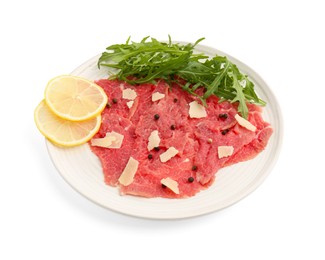 Fresh beef carpaccio with arugula, lemon and cheese isolated on white