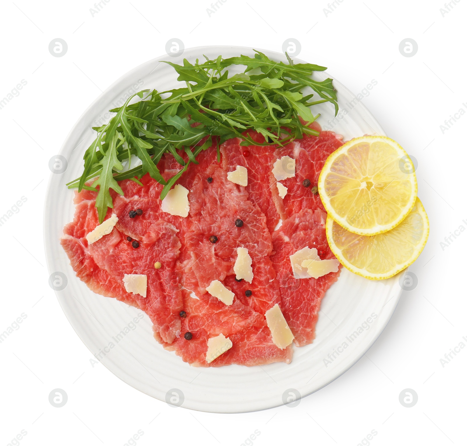 Photo of Fresh beef carpaccio with arugula, lemon and cheese isolated on white, top view