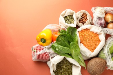 Photo of Shopper bags with products on orange background, flat lay and space for text. Eco friendly lifestyle