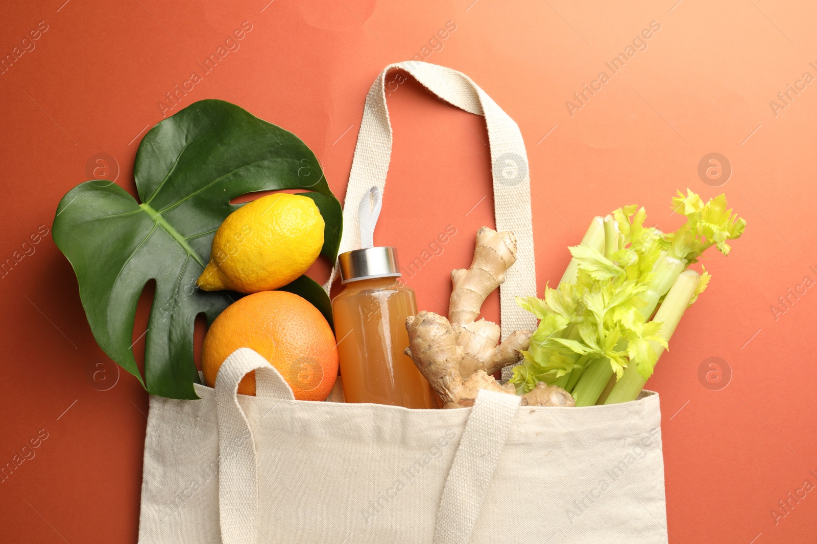 Photo of Shopper bag with products on orange background, top view. Eco friendly lifestyle