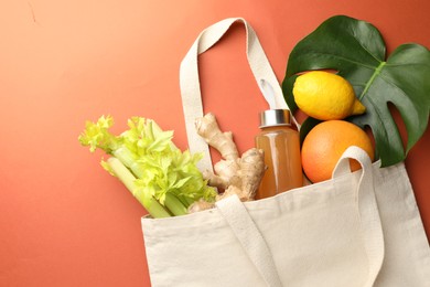 Photo of Shopper bag with products on orange background, top view. Eco friendly lifestyle