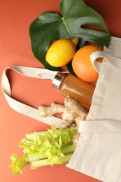 Photo of Shopper bag with products on orange background, top view. Eco friendly lifestyle