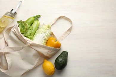 Photo of Shopper bag with products on white wooden background, top view and space for text. Eco friendly lifestyle