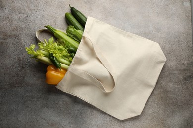 Photo of Shopper bag with products on grey background, top view. Eco friendly lifestyle