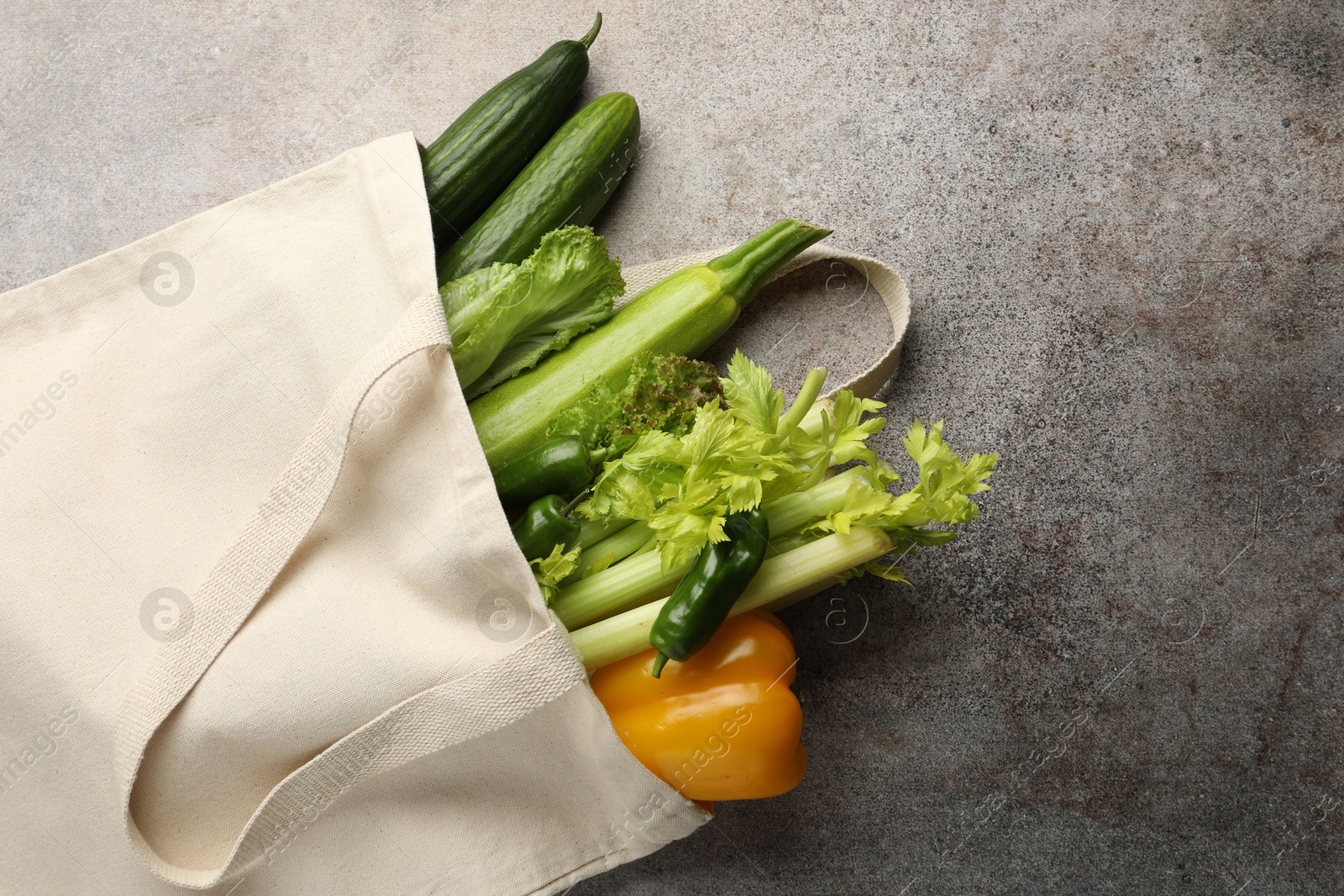 Photo of Shopper bag with products on grey background, top view and space for text. Eco friendly lifestyle