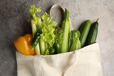 Photo of Shopper bag with products on grey background, top view. Eco friendly lifestyle