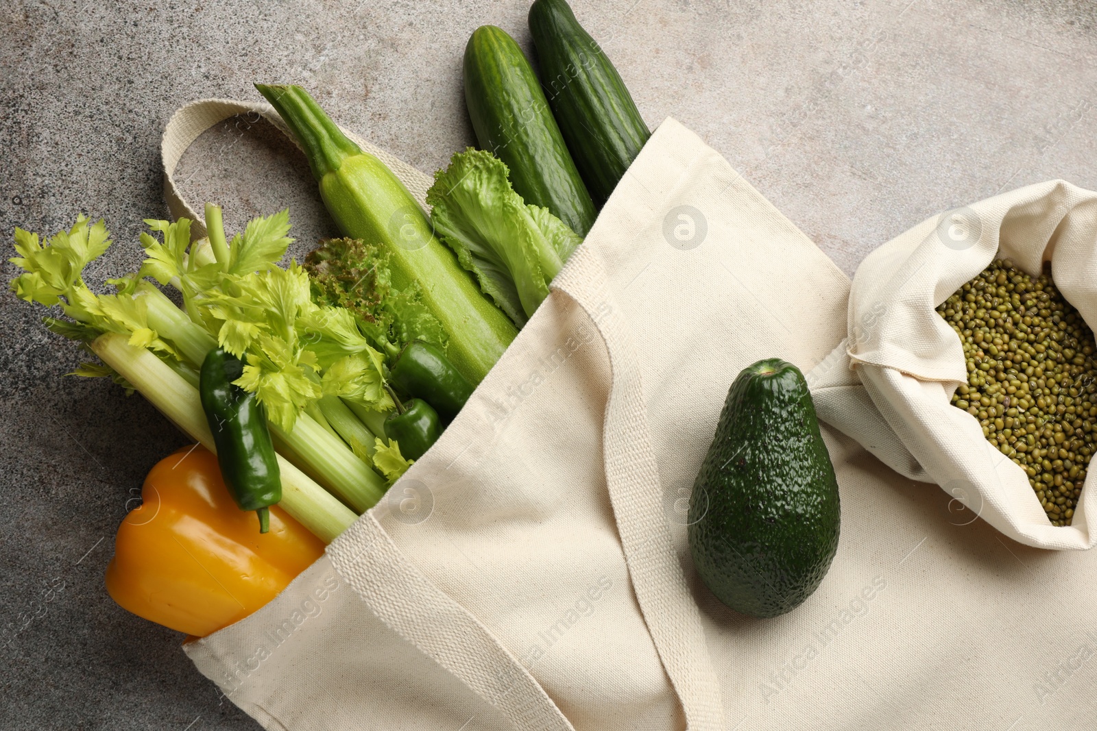 Photo of Shopper bag with products on grey background, top view. Eco friendly lifestyle